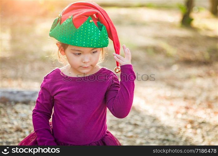 Cute Mixed Race Young Baby Girl Having Fun Wearing Christmas Hat Outdoors.
