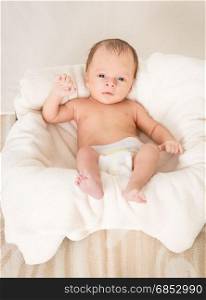 Cute newborn baby with blue eyes lying in basket
