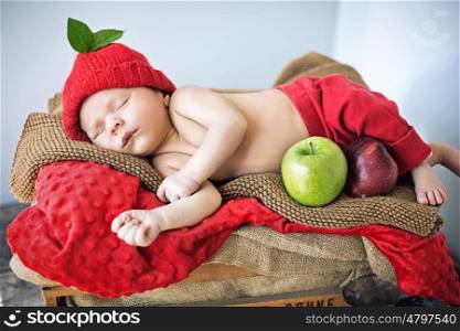 Cute newborn child sleeping on a soft red blanket