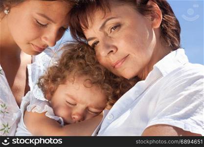 Cute Portrait of Happy Mother and Two Daughters at the Sunny Summer Day