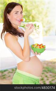 Cute pregnant girl having breakfast on the kitchen at home, happy motherhood, healthy pregnancy concept