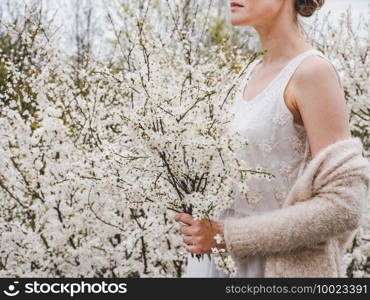 Cute, pretty woman on the background of flowering trees. Concept of rest and relaxation. Cute woman on the background of flowering trees
