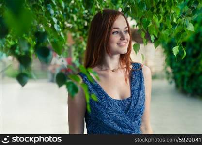 Cute red haired women smiling outdoors.