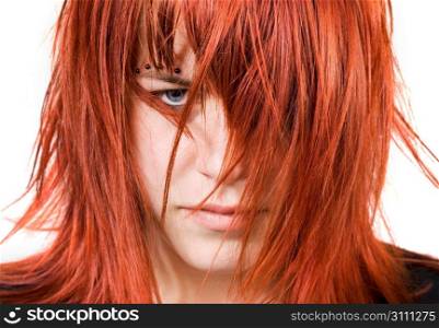 Cute redhead girl looking aggressively at the camera with messy or distressed hair. Studio shot.