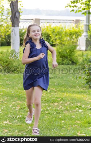 Cute running European girl with disheveled hair in green park