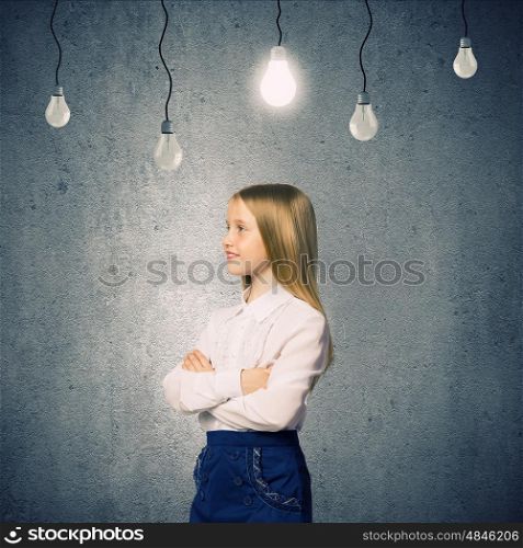 Cute school girl against grey wall with bulbs hanging above. Wunderkind