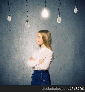 Cute school girl against grey wall with bulbs hanging above. Wunderkind