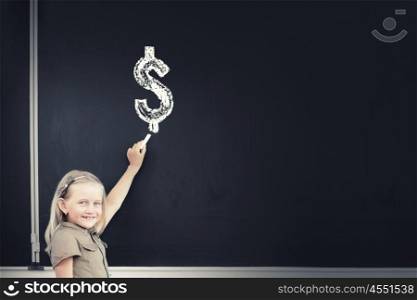 Cute school girl drawing dollar sign on blackboard. Money science
