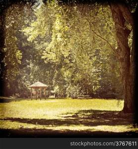 Cute shelter in a park with huge trees in a vintage filter