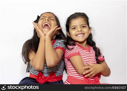 Cute sisters with striped dresses laughing