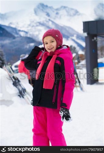 Cute smiling girl throwing snowball at highland resort