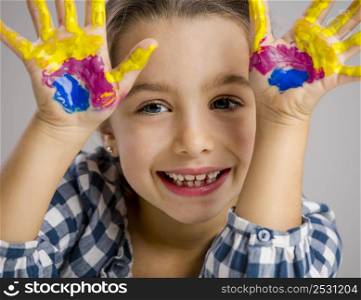 Cute smiling little girl with hands in paint