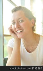 cute smiling woman sitting in cafe and looking at camera