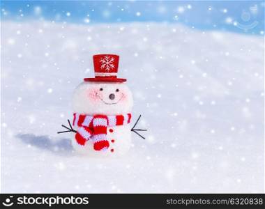 Cute snowman outdoors in snowy weather, traditional winter symbol, little smiling snowman wearing red hat and scarf, Christmas greeting card