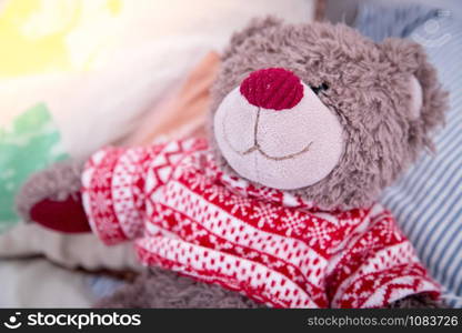 Cute teddy bear toy is sitting in the bed, wakeup at morning