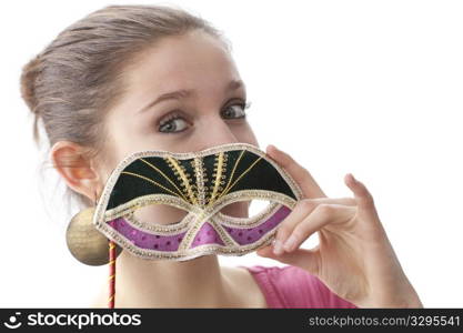 Cute teenage girl with a Venitian carnival mask on white background