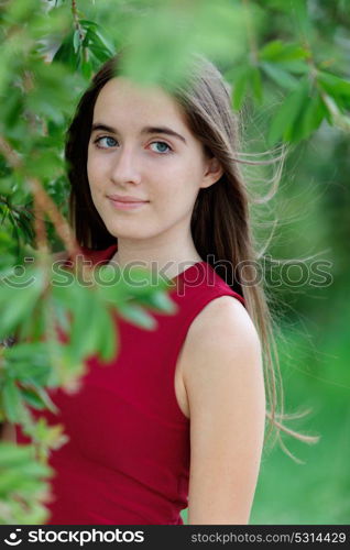 Cute teenager girl in a park surrounded by plants