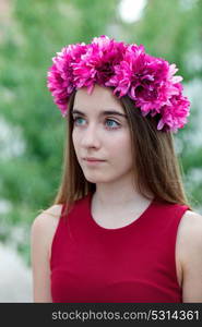 Cute teenager girl in a park with a beautiful wreath on her head