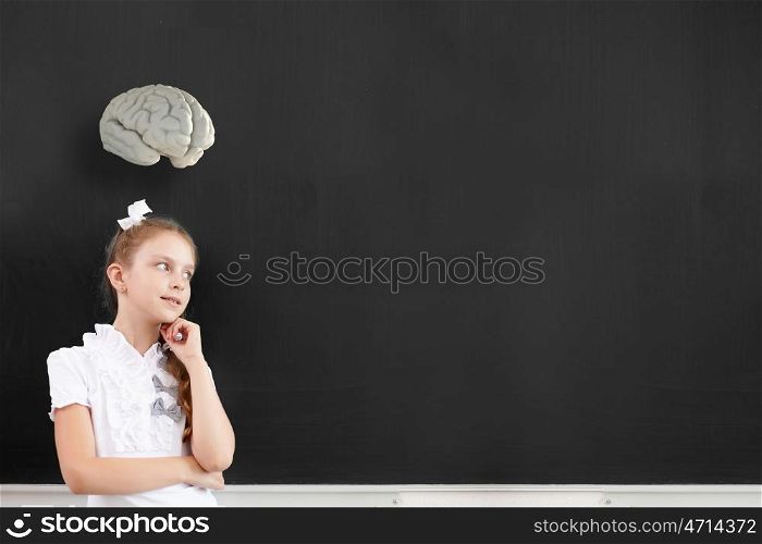 Cute thoughtful school girl and brain above her head. Let me think