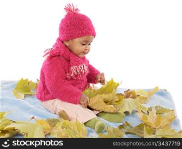 Cute toddler girl playing with fallen leaves