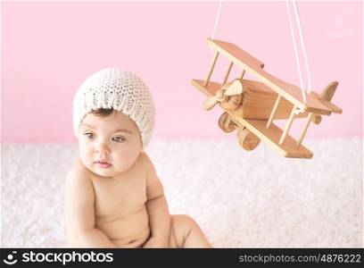 Cute toddler playing with a wooden plane