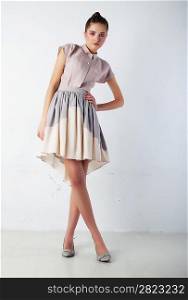 Cute woman fashion model in gorgeous light dress posing in studio