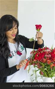Cute woman using scissors to cut the stems of flower bouquets