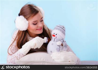 Cute woman with little snowman. Winter.. Pretty cute woman holding little snowman. Attractive girl in studio on blue. Winter.