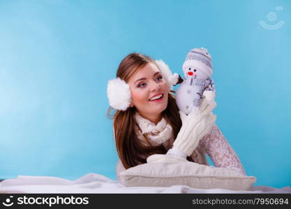 Cute woman with little snowman. Winter.. Pretty cute woman holding little snowman. Attractive girl in studio on blue. Winter.