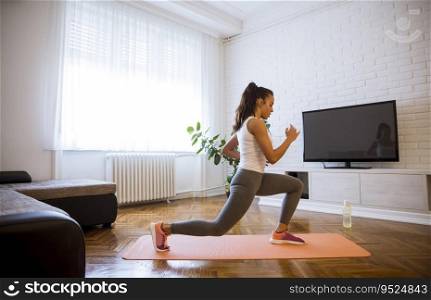 Cute young attractive woman practicing exercises at home