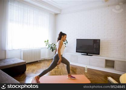 Cute young attractive woman practicing exercises at home