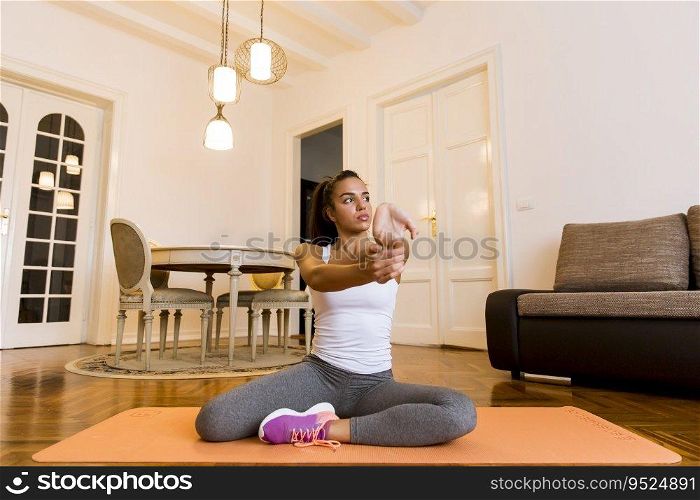 Cute young attractive woman practicing exercises on the floor at home