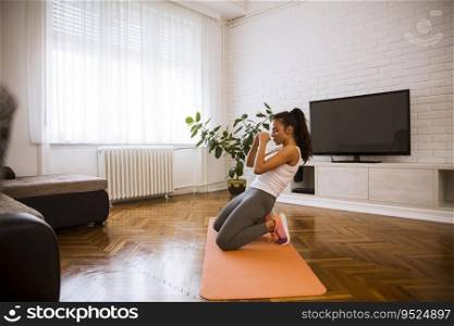 Cute young attractive woman practicing exercises on the floor at home