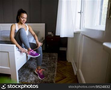 Cute young attractive woman preparing for exercises at home