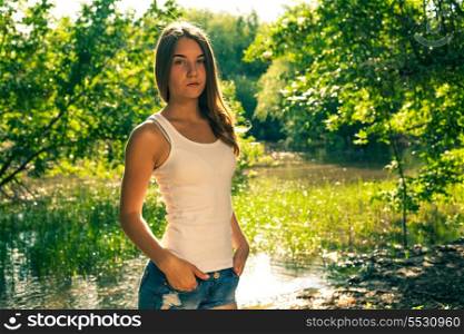 Cute young blonde woman in white tank top and denim shorts colorized toned imade