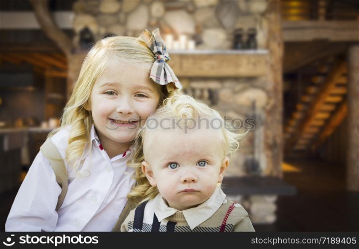 Cute Young Brother and Sister Pose In Rustic Cabin.