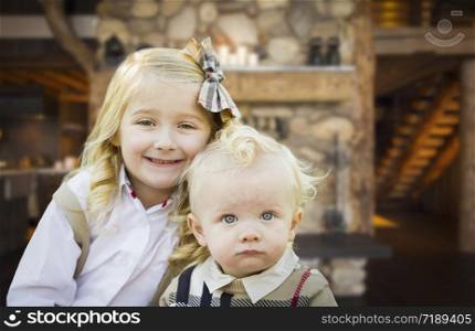 Cute Young Brother and Sister Pose In Rustic Cabin.