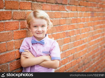 Cute Young Caucasian Boy Portrait Against A Brick Wall.