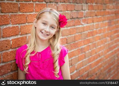 Cute Young Caucasian Girl Portrait Against A Brick Wall.