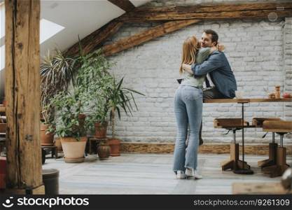 Cute young couple hugging while cooking in their apartment kitchen