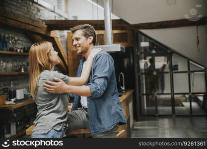 Cute young couple hugging while cooking in their apartment kitchen