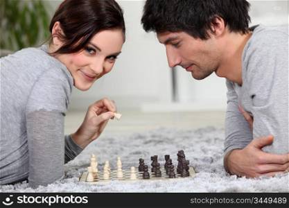 cute young couple playing chess together