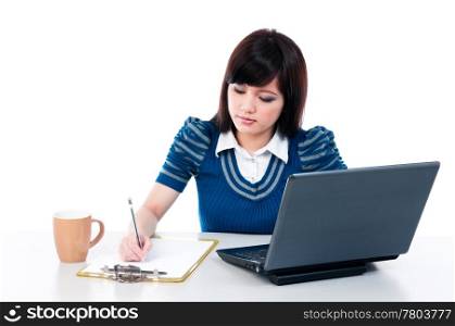 Cute young female with laptop and writing on clipboard