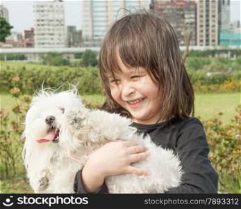 Cute young girl holding dog at park