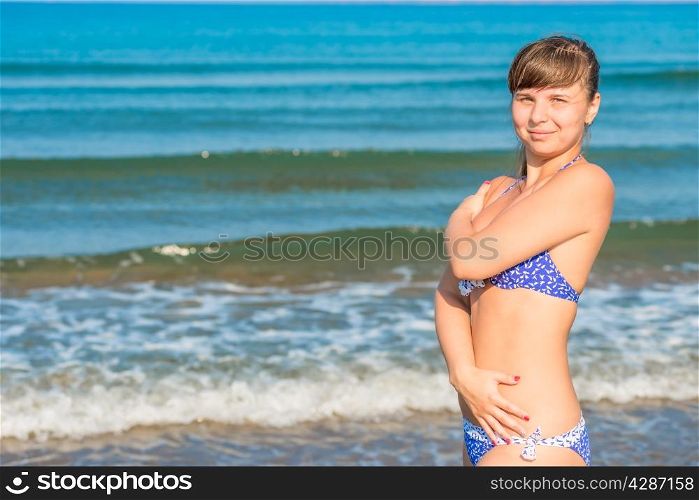 cute young girl in swimsuit posing near the sea
