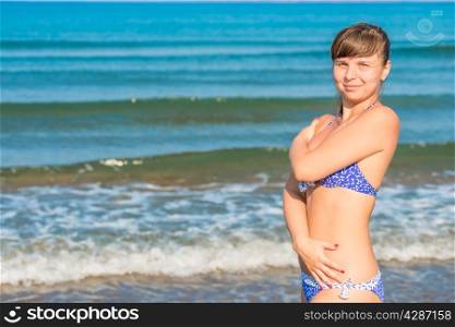 cute young girl in swimsuit posing near the sea