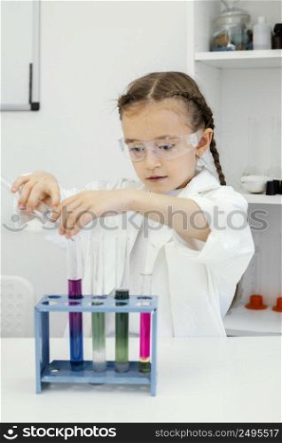 cute young girl scientist with test tubes doing experiments