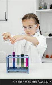 cute young girl scientist with test tubes doing experiments