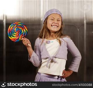 Cute young girl with lollipop and knit cap