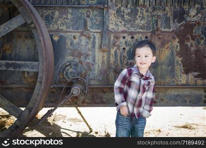 Cute Young Mixed Race Boy Having Fun Near Antique Machinery Outside.